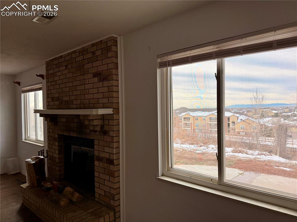 Image 27 of 42: Unfurnished living room featuring a fireplace and a residential view
