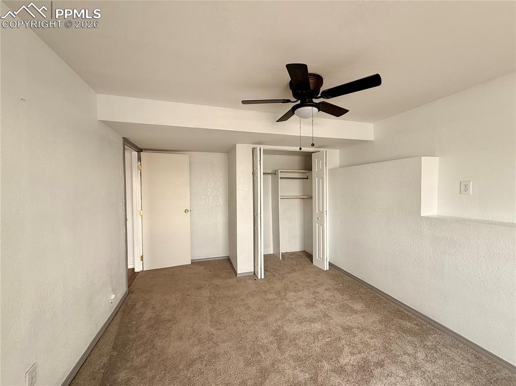 Image 29 of 42: Unfurnished bedroom featuring a textured wall, a ceiling fan, carpet, and a