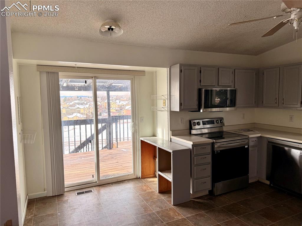 Image 7 of 42: Kitchen featuring stainless steel appliances, light countertops, gray cabin