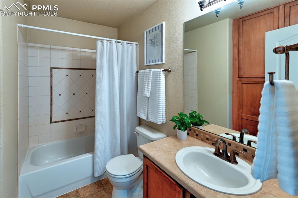 Image 23 of 33: Hall bath with tile tub and shower combo