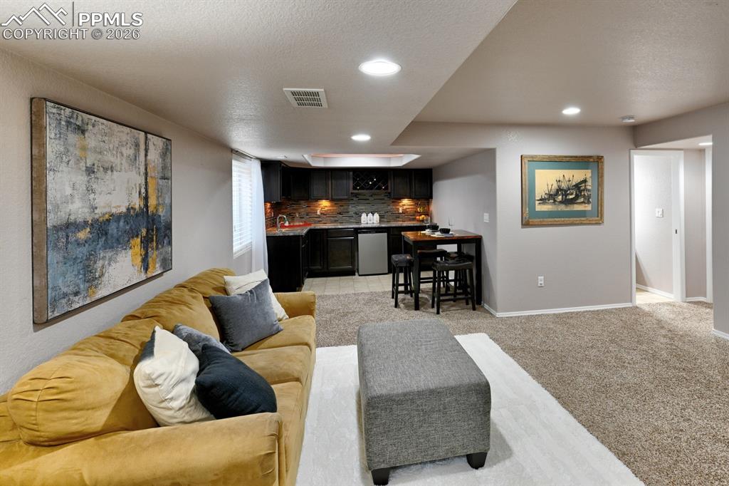 Image 24 of 33: Spacious basement family room with large wet bar