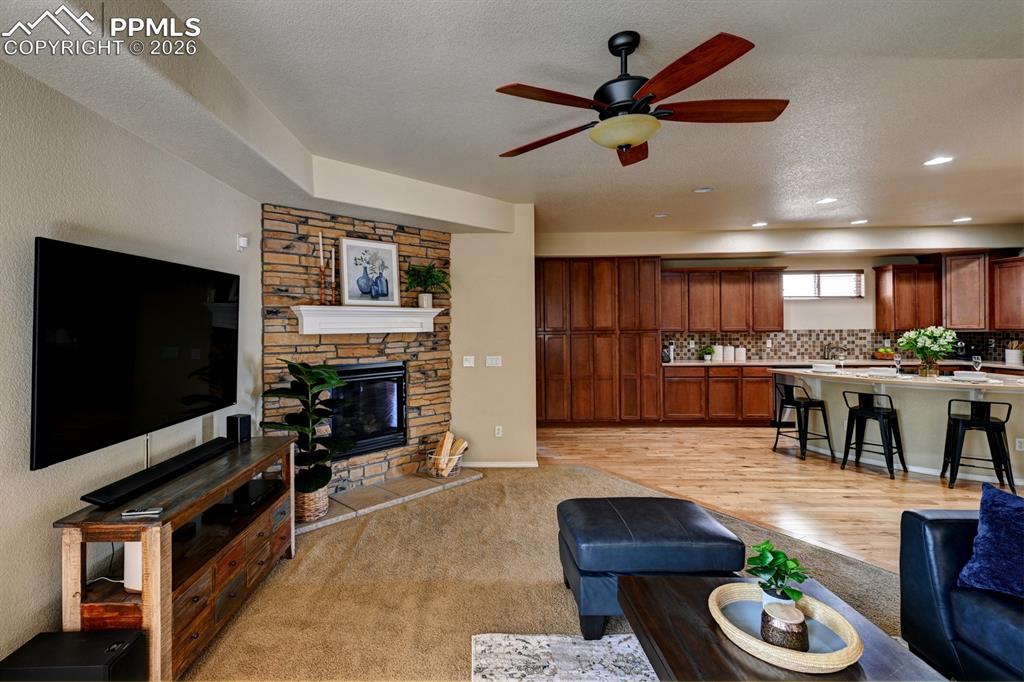 Image 5 of 33: Stone faced gas fireplace anchors the living space with open flow through t