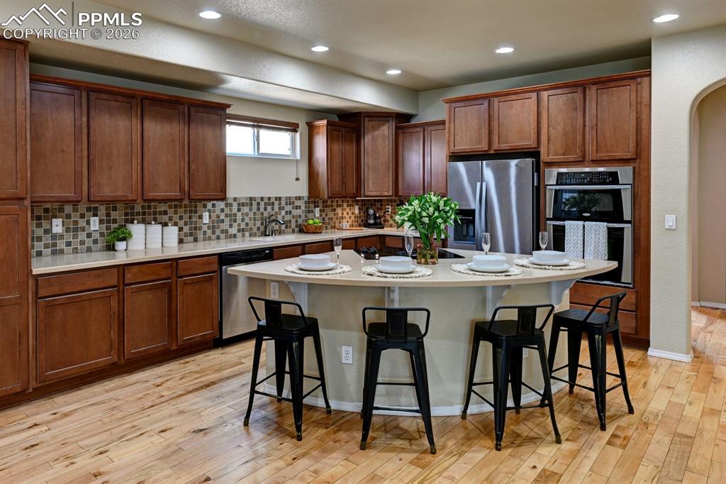 Image 7 of 33: Well designed kitchen with rich birch cabinetry, solid surface countertops,
