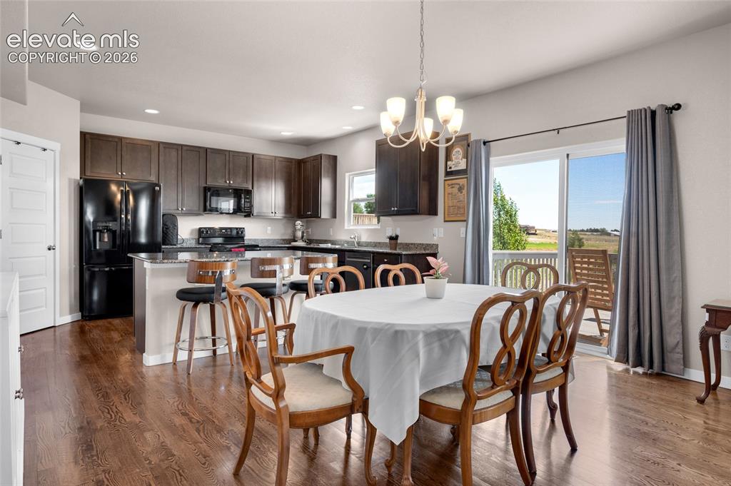 Image 10 of 47: Dining area and kitchen enjoys a beautiful hardwood floor and patio access