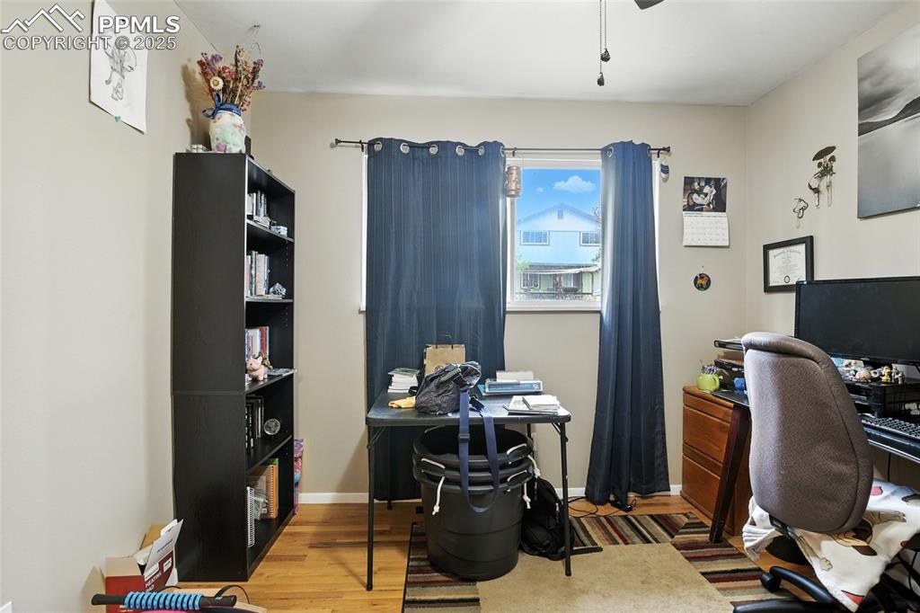 Image 15 of 35: Office space with light wood-type flooring and a ceiling fan