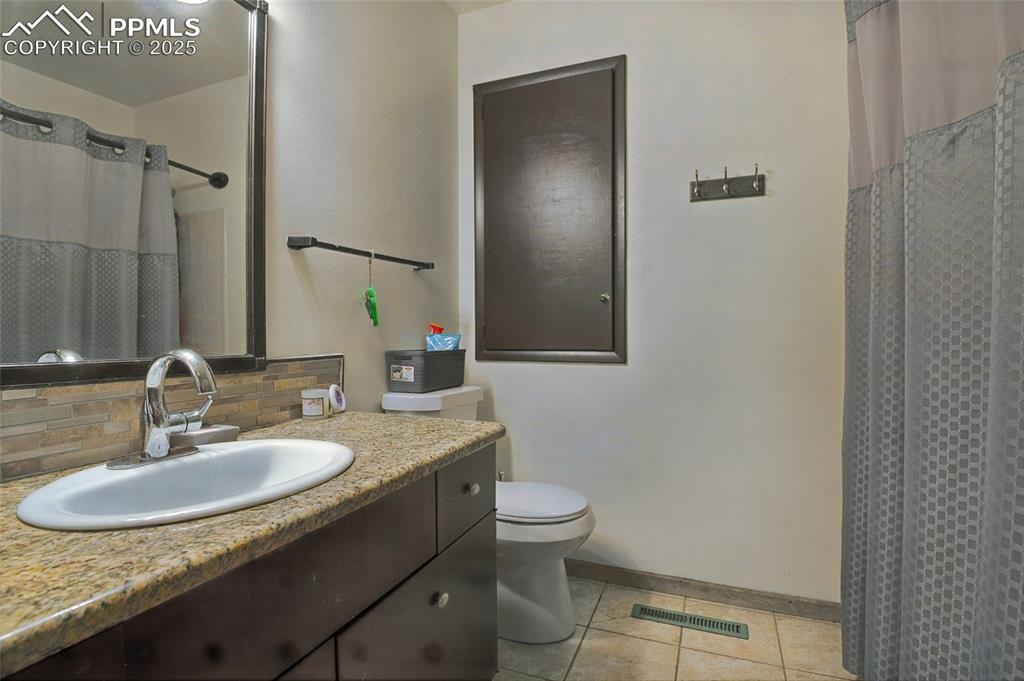 Image 22 of 35: Full bathroom featuring vanity, light tile patterned flooring, decorative b