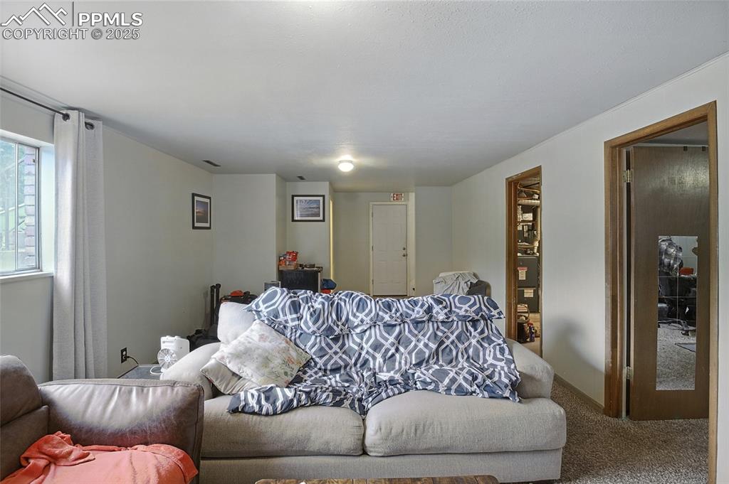 Image 25 of 35: Living room with carpet floors and baseboards