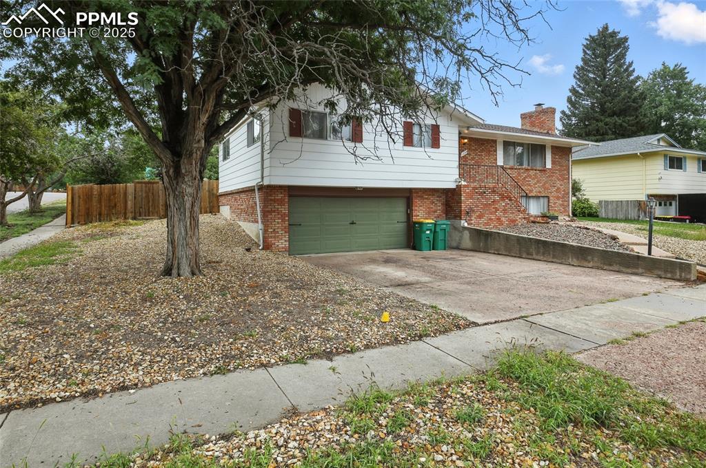 Image 3 of 35: View of front of home featuring concrete driveway, brick siding, a garage, 
