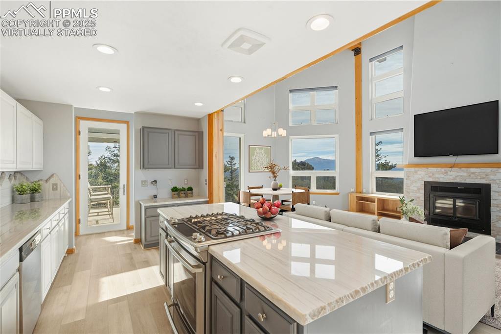 Image 12 of 50: Virtually Staged - Kitchen featuring stainless steel appliances, light ston