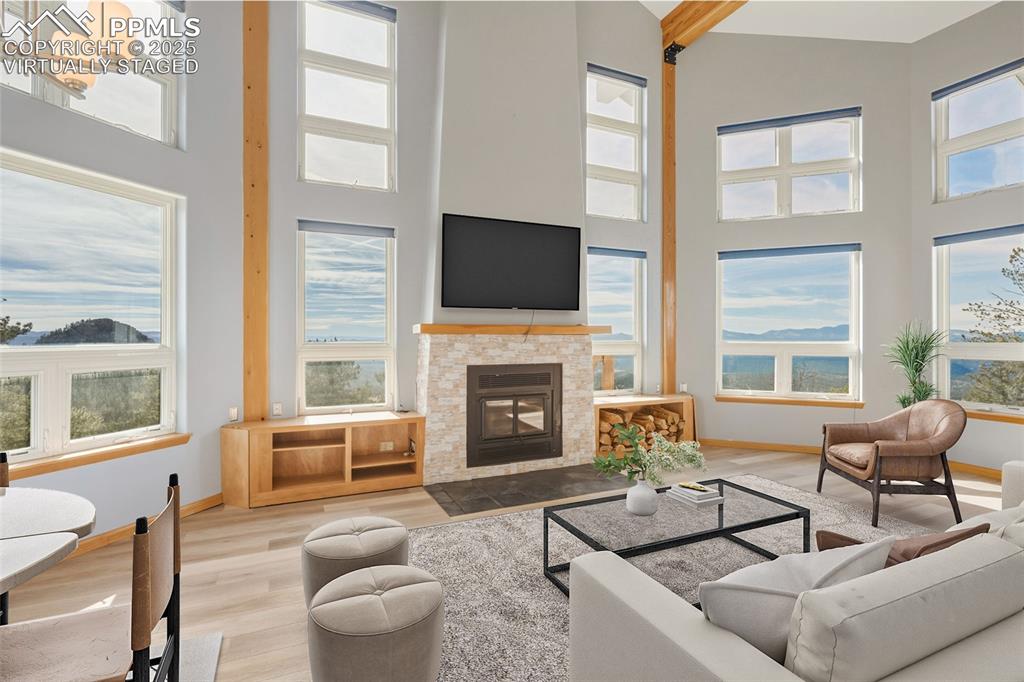 Image 2 of 50: Virtually Staged - Living room with a fireplace with flush hearth, wood fin