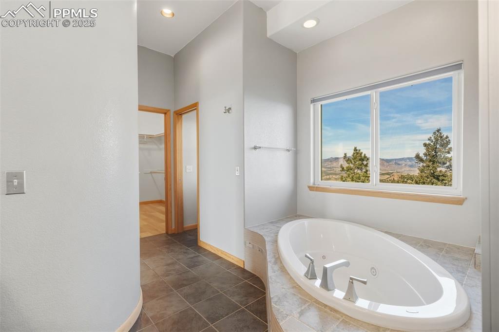 Image 27 of 50: Full bathroom with a spacious closet, a jetted tub, a mountain view, recess