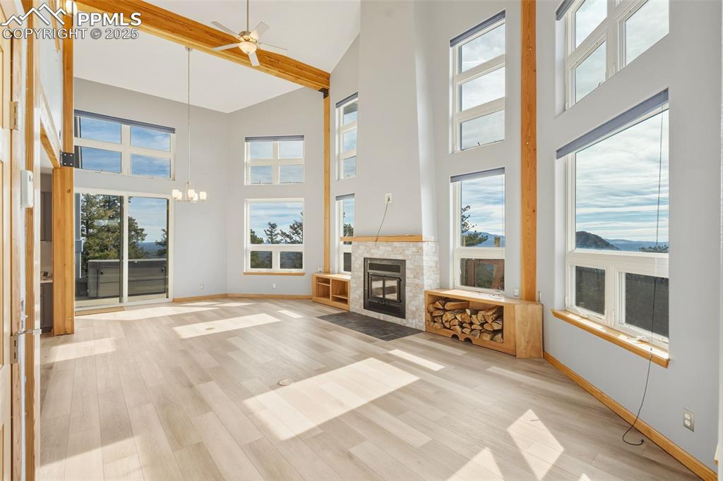 Image 46 of 50: Unfurnished living room featuring beamed ceiling, a ceiling fan, light wood