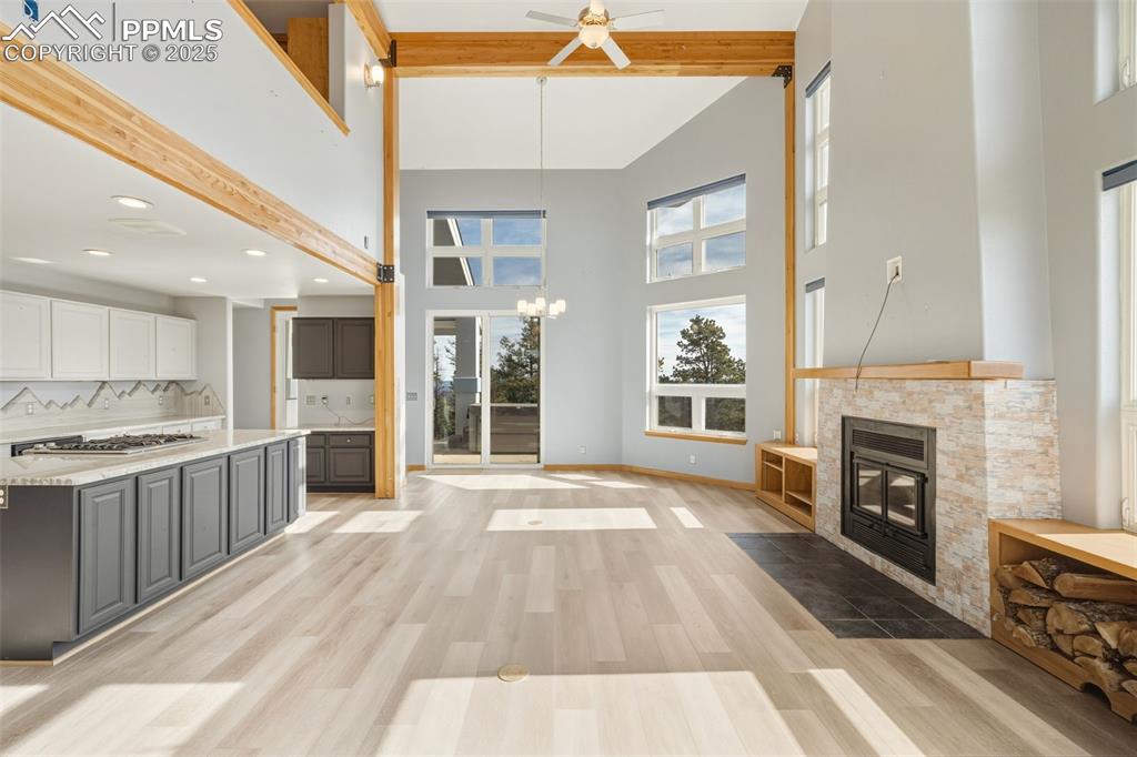 Image 50 of 50: Kitchen featuring beam ceiling, white cabinets, tasteful backsplash, light