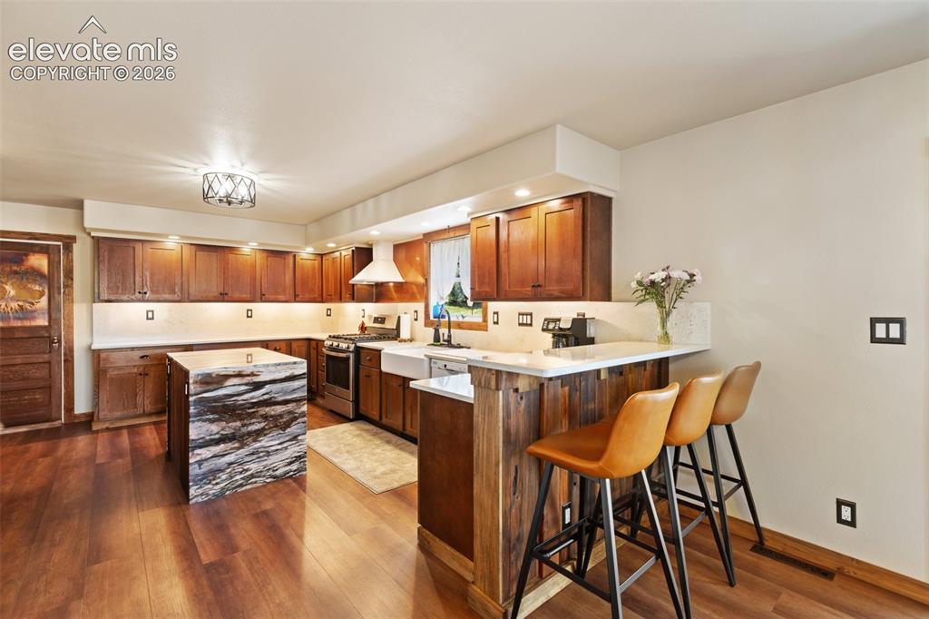 Image 17 of 50: Kitchen Island and Breakfast bar. 