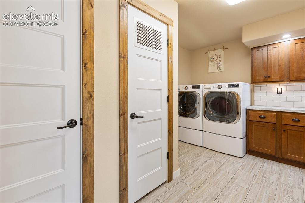 Image 37 of 50: Laundry with storage cabinets and folding space.