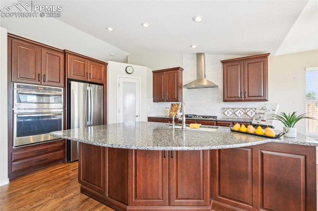 Image 10 of 45: Attractive hood and stainless steel appliances.