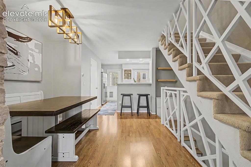 Image 14 of 42: Open-concept dining area featuring wood-finish flooring, a contemporary lin