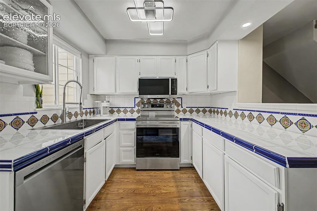 Image 17 of 42: U-shaped kitchen featuring white cabinetry, integrated stainless steel appl