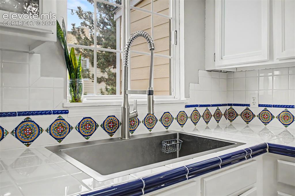 Image 19 of 42: Kitchen sink area featuring an undermount stainless steel sink with a high-