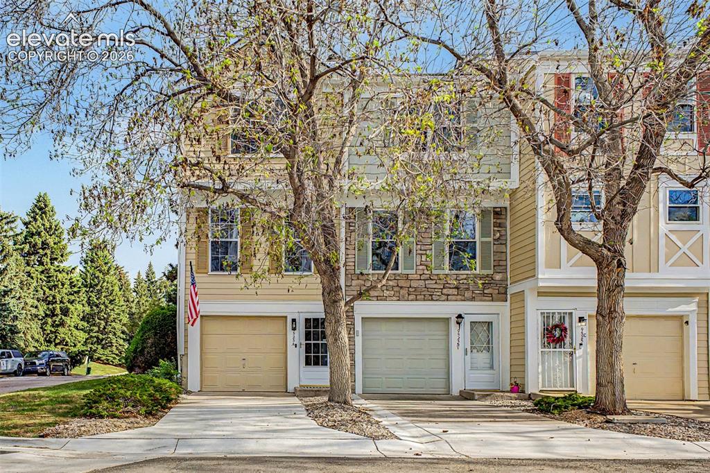 Image 2 of 42: Multi-level townhome featuring a stone facade and beige siding