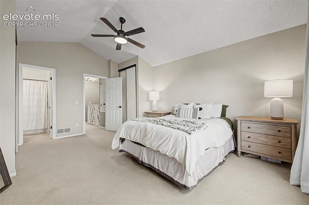 Image 24 of 42: Carpeted room featuring a vaulted ceiling and a ceiling fan with integrated