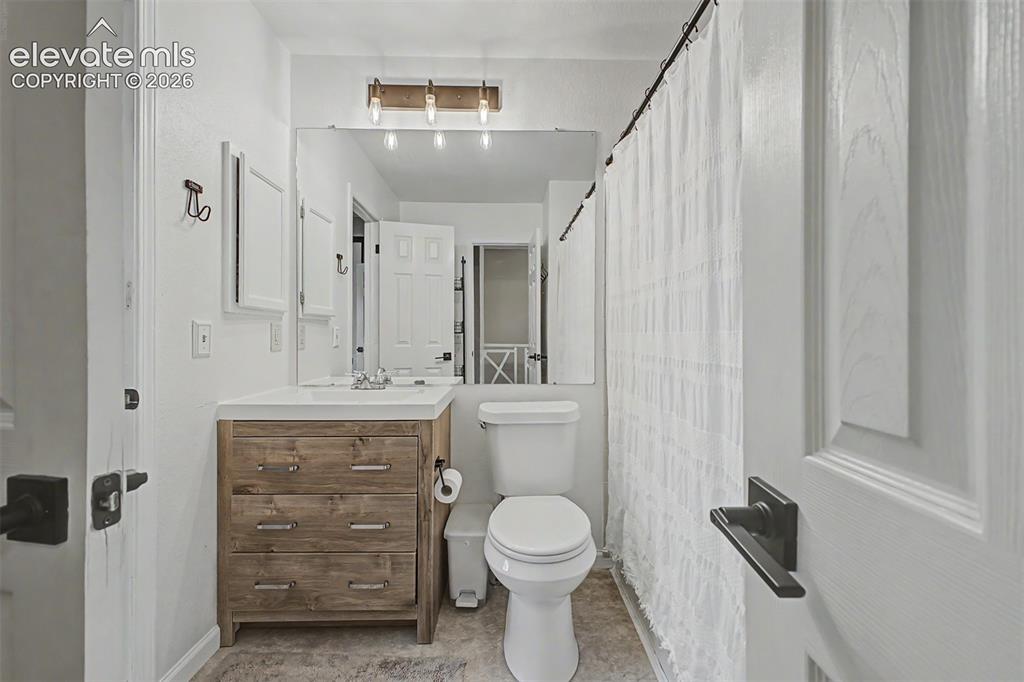 Image 27 of 42: Bathroom featuring a wood-finish vanity with drawer storage, white countert