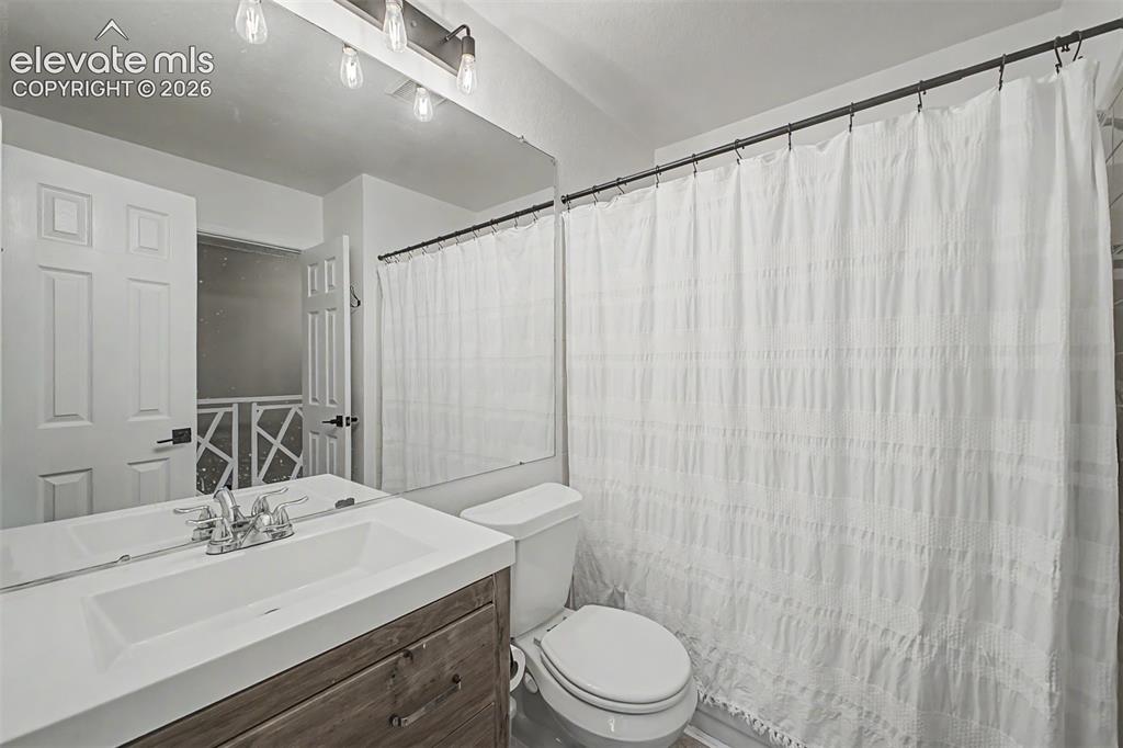 Image 28 of 42: Bathroom vanity with an integrated white sink and a wood-finish cabinet