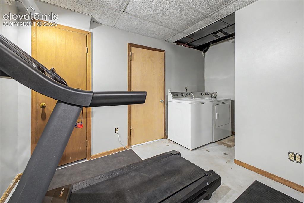 Image 30 of 42: Dedicated laundry area featuring a white washing machine and a white clothe