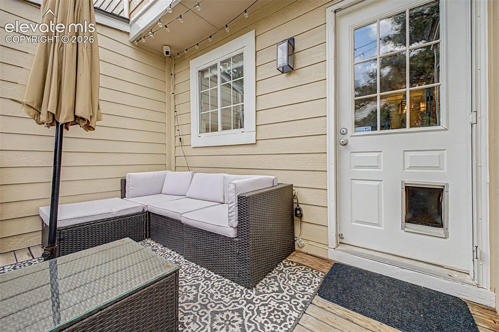 Image 33 of 42: Outdoor patio area featuring composite decking, decorative outdoor rug, and
