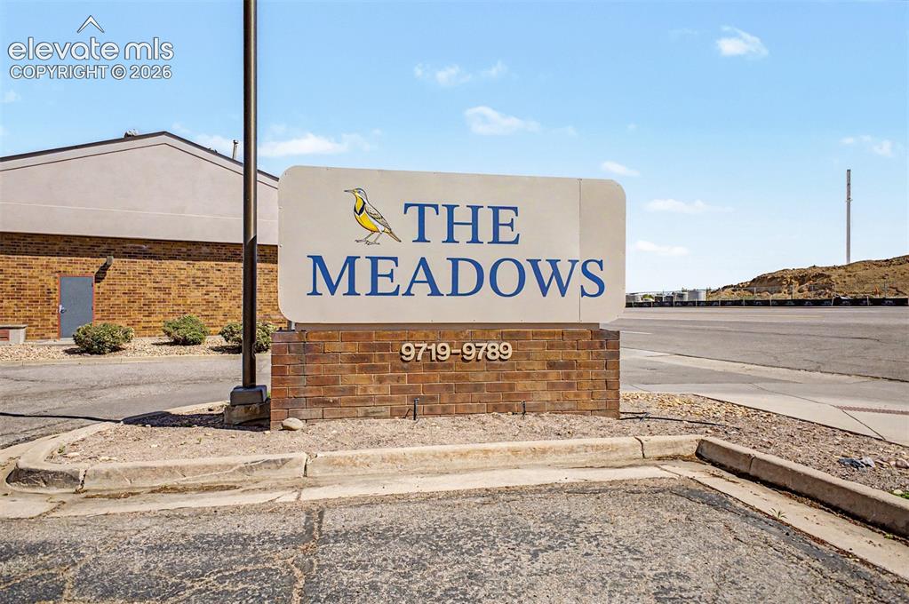 Image 37 of 42: Property signage featuring a brick base and an illuminated sign with addres