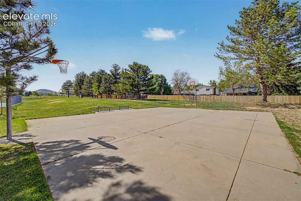 Image 41 of 42: Concrete basketball court with dual hoops