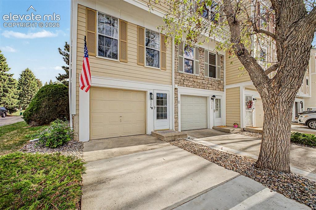 Image 5 of 42: Two-story townhome featuring light-colored siding and stone accent facade