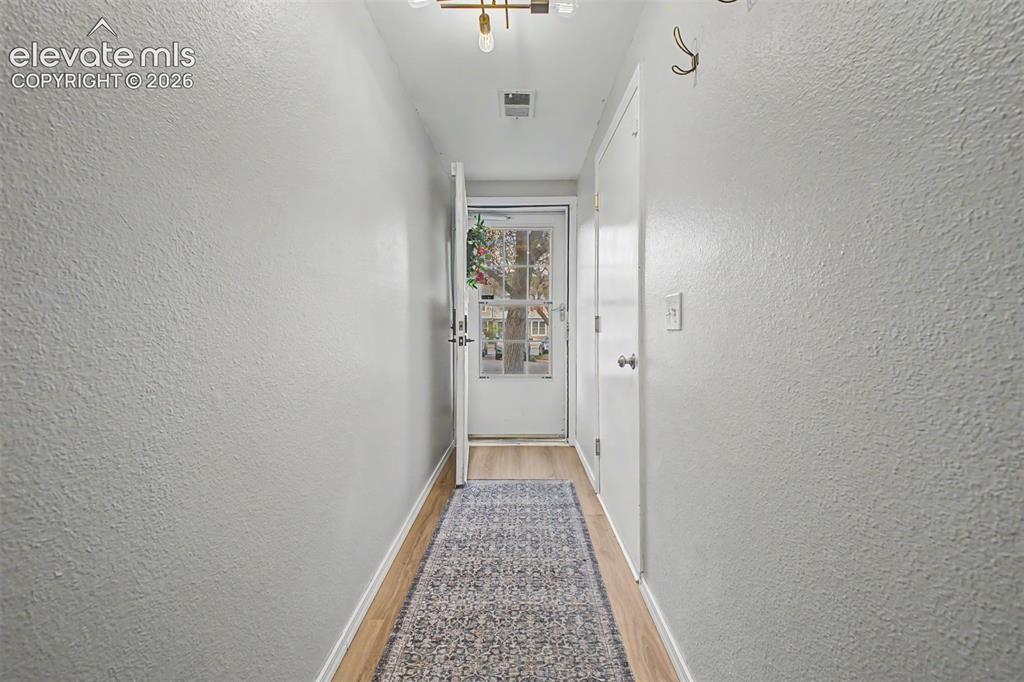 Image 6 of 42: Entryway featuring light-toned wood-finish flooring and textured walls