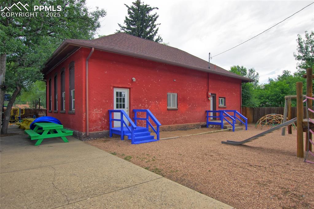 Caption: View of side of property featuring brick siding and a playground