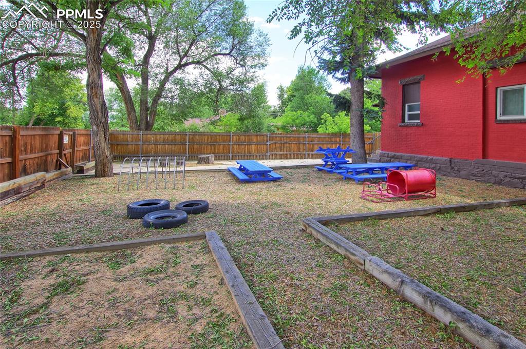 Image 29 of 34: Fenced backyard featuring a vegetable garden