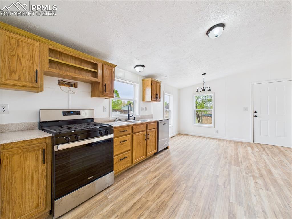 Image 11 of 44: Functional and attractive kitchen boasting light countertops, a stainless s