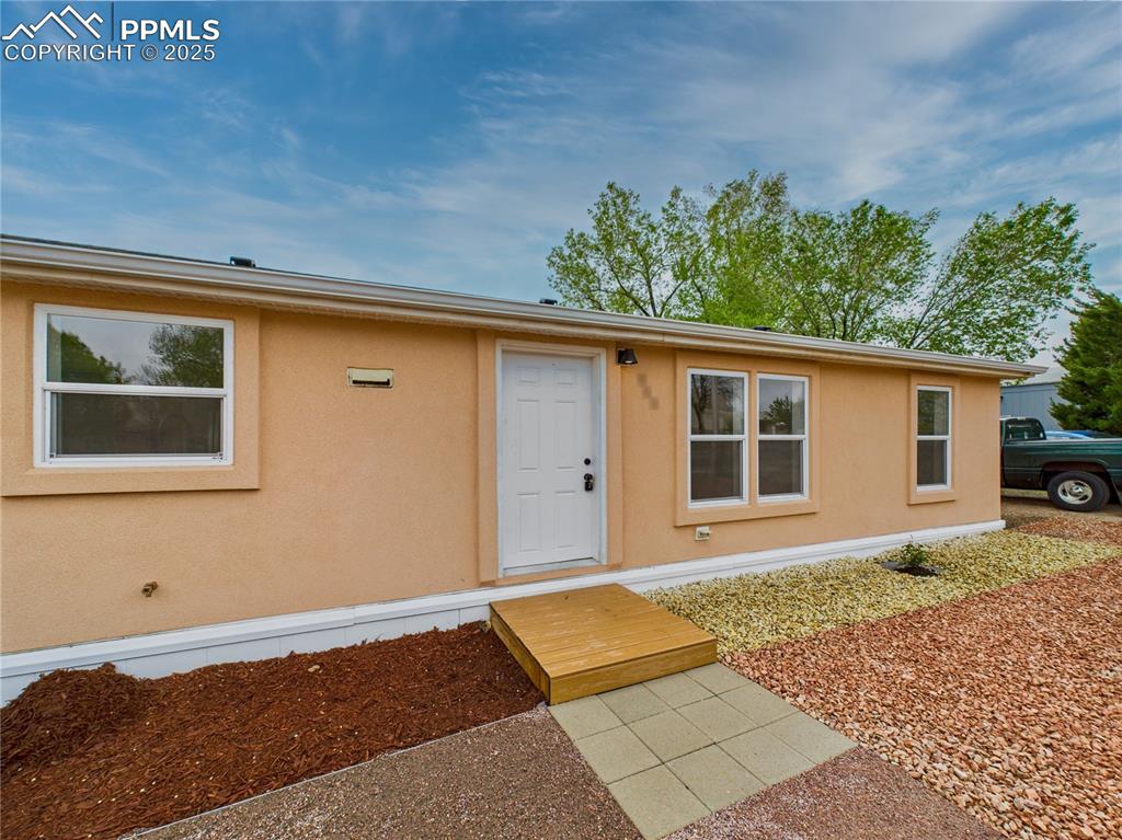 Image 2 of 44: Charming stucco exterior with a beautifully landscaped front yard