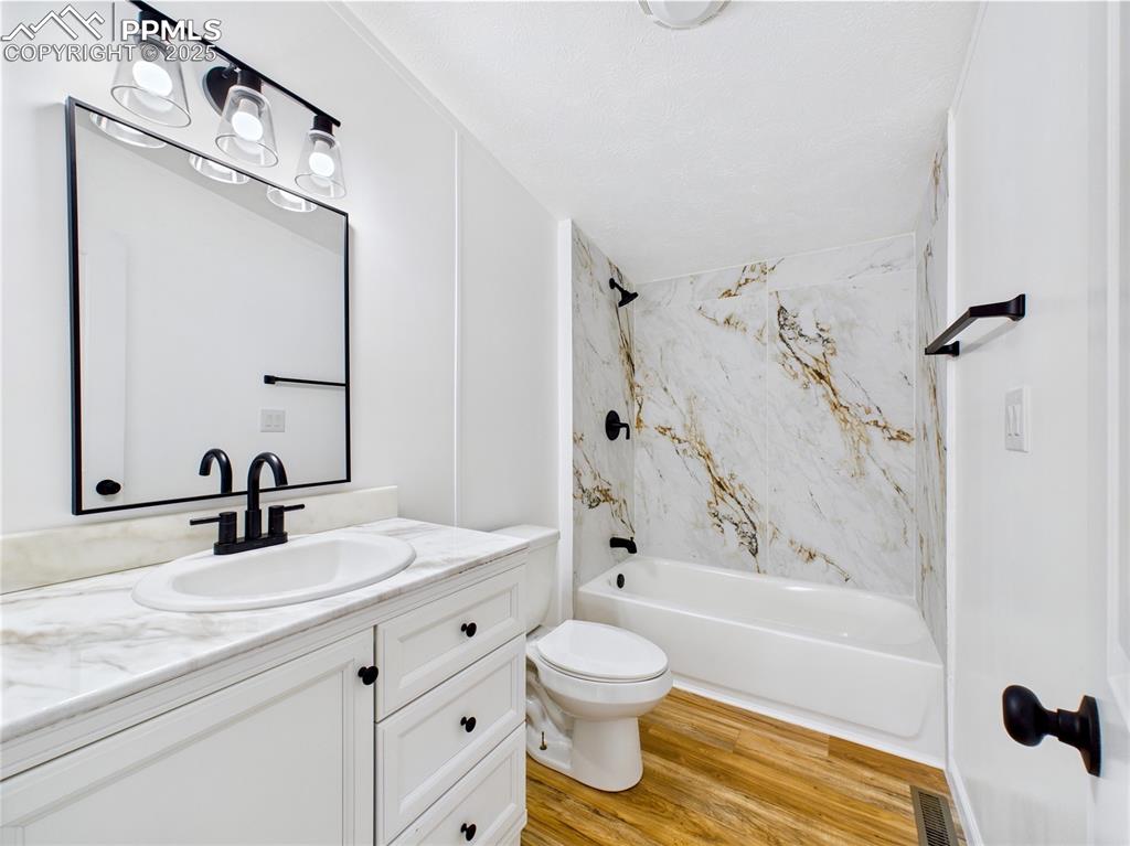 Image 37 of 44: Full bathroom featuring a new vanity, toilet, and a bathtub/shower combo