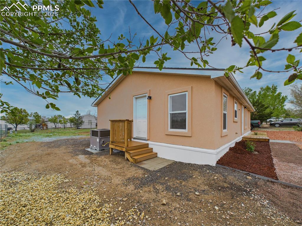 Image 41 of 44: Stucco-sided exterior with central air conditioning unit and convenient sid