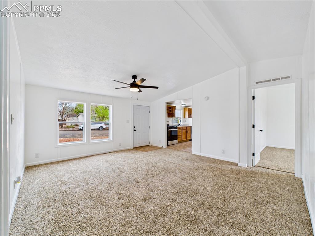 Image 9 of 44: Bright and inviting living room with impressive vaulted ceilings