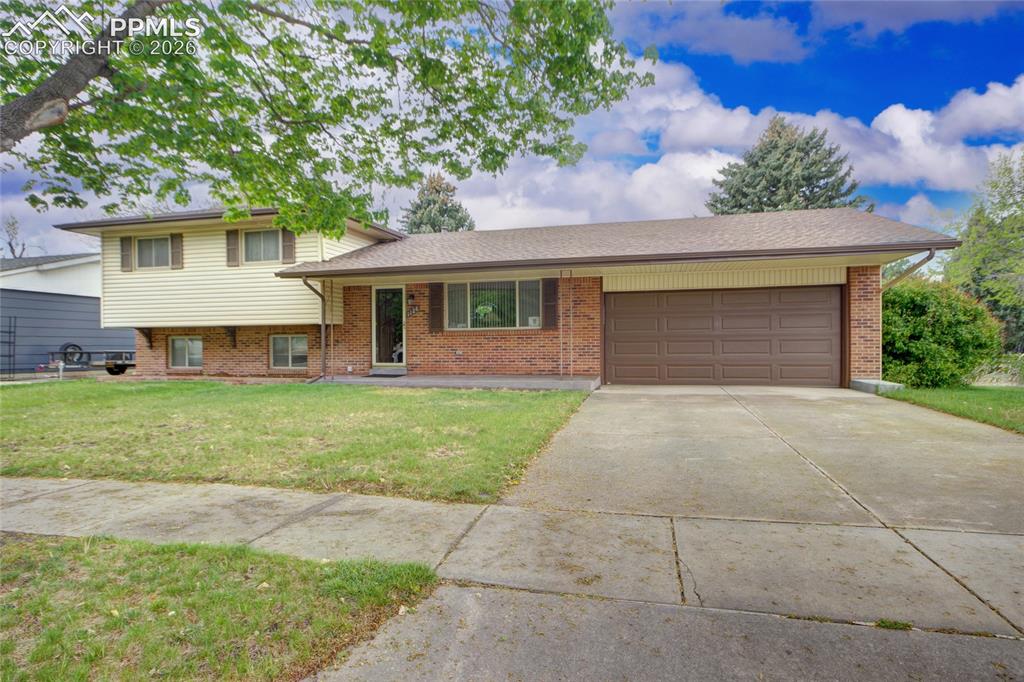 Image 1 of 33: Split-level residence featuring a brick facade, light-colored siding, and a