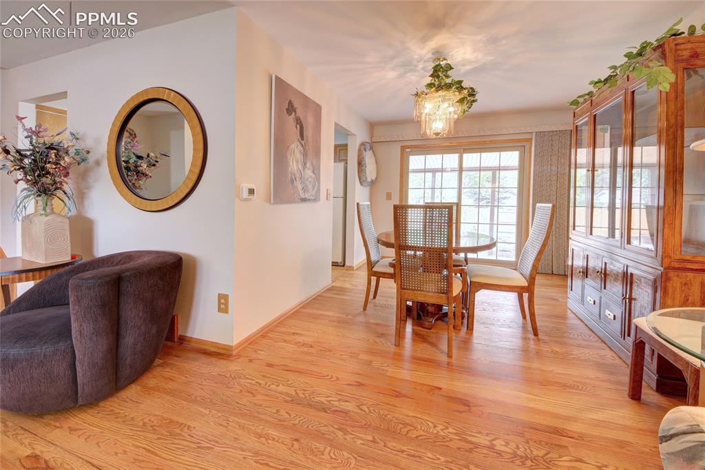 Image 10 of 33: Dining area featuring wood-finish flooring, a glass-top dining table, and d