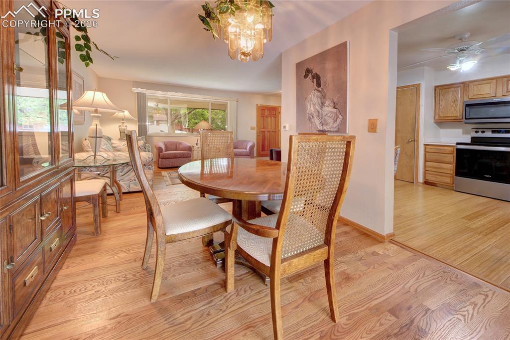 Image 12 of 33: Open-concept dining area featuring wood-finish flooring and a decorative ch