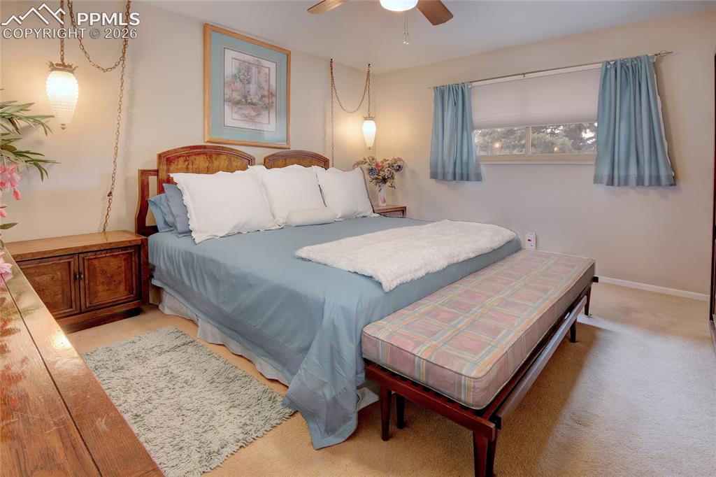 Image 17 of 33: Neutral-toned bedroom featuring wall-to-wall carpeting and a window with bl