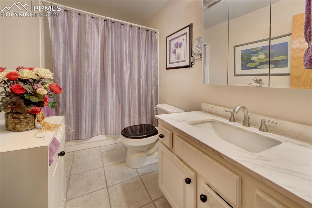 Image 23 of 33: Bathroom featuring a single vanity with a solid surface countertop, an inte
