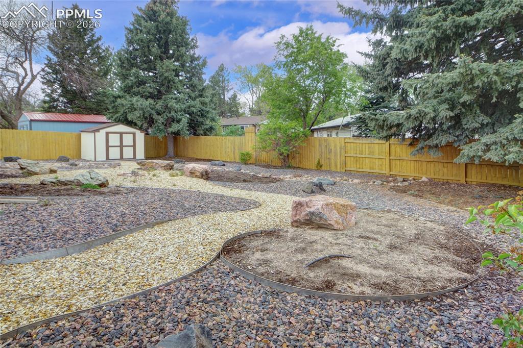 Image 30 of 33: Spacious backyard featuring a new privacy fence, an integrated storage shed