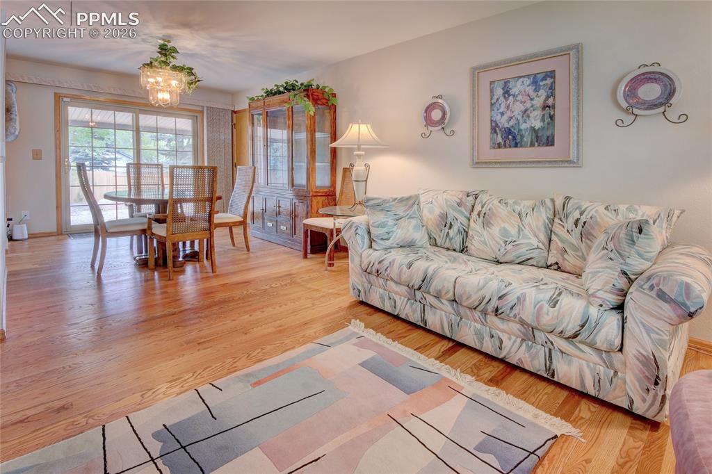 Image 5 of 33: Open-concept living and dining area featuring wood-finish flooring, a decor