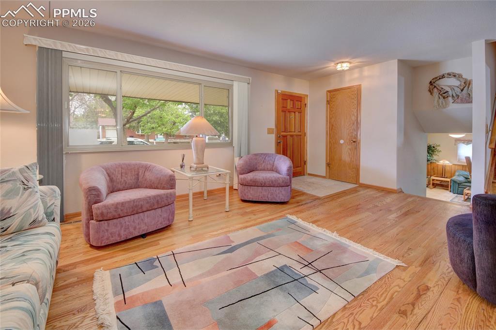 Image 7 of 33: Living area featuring wood-finish flooring, a broad picture window with bli