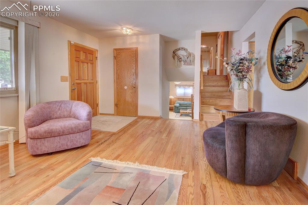Image 9 of 33: Hardwood flooring extends throughout this entryway, featuring a light wood 