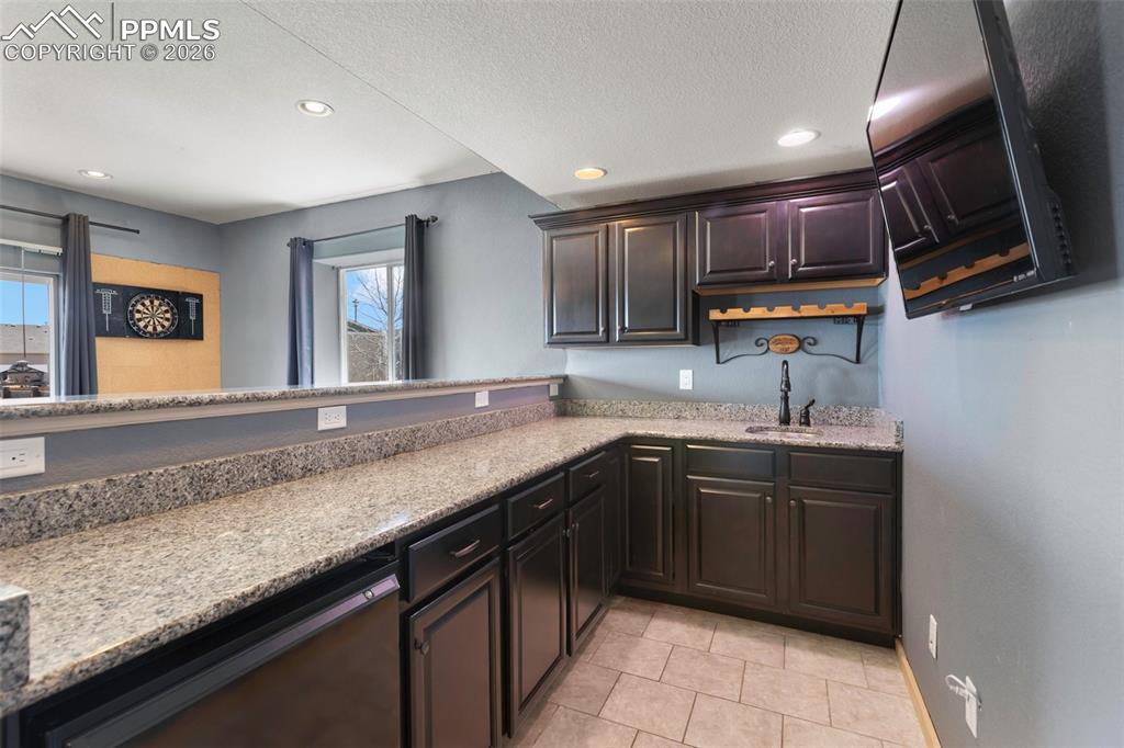 Image 31 of 45: Convenient wet bar that adds style to the basement